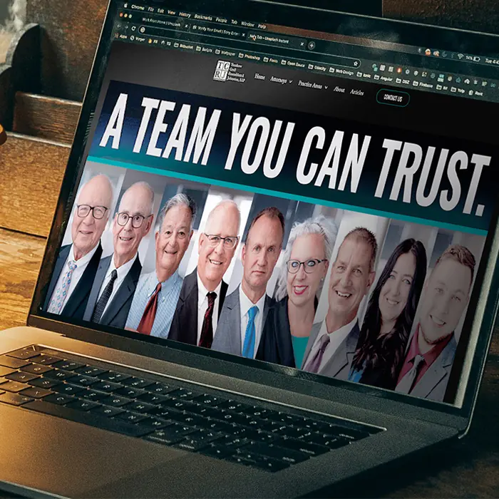 TCRJ Law website on a laptop, showing the firm’s attorneys